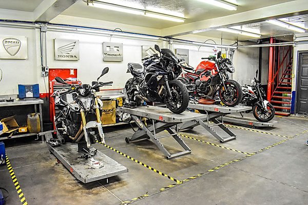 Motorcycles on stands inside a two-wheeler service workshop